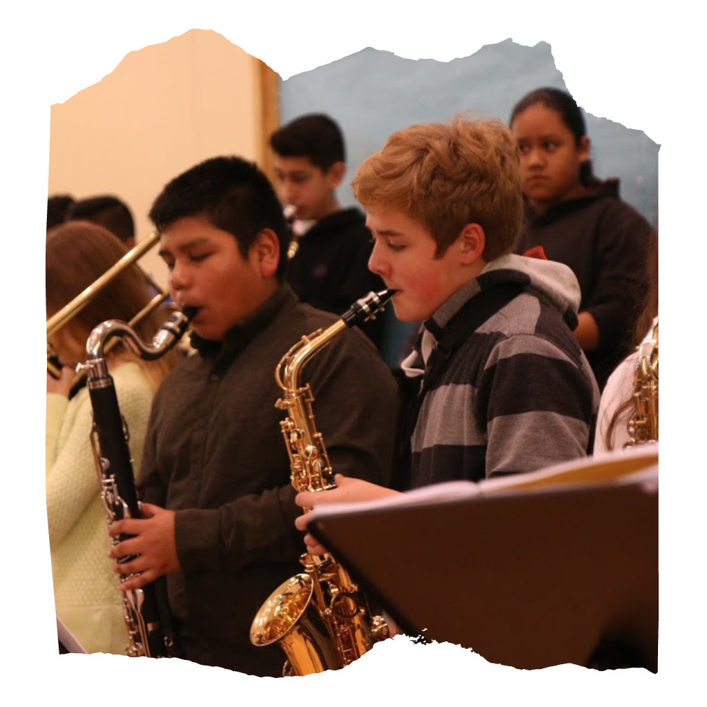A group of musical students, for ground two young male students player the saxophone.