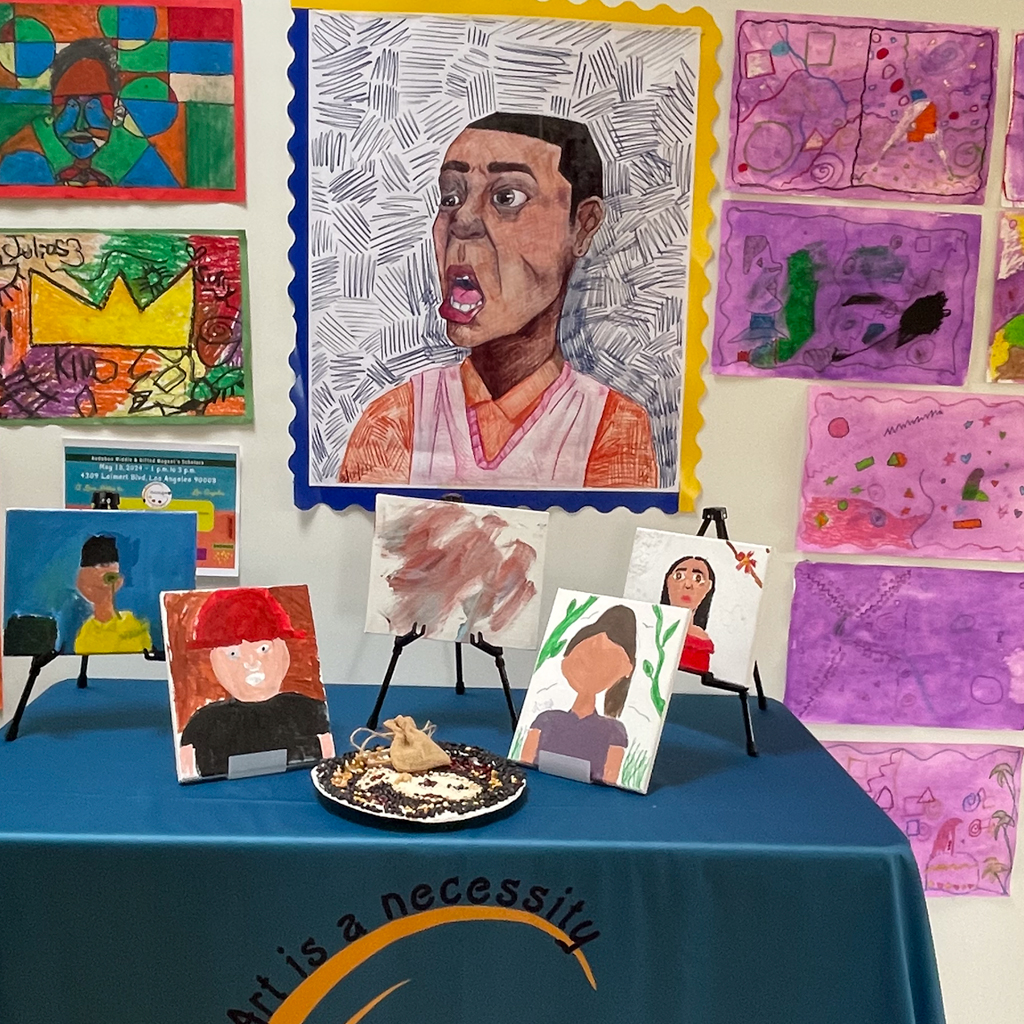 Student work exhibition wall and table, works done by middle school students, taught by Pulse Arts teaching artist Estrella Fernandez.